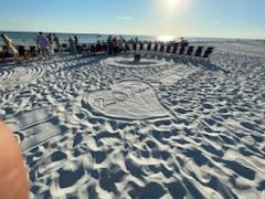 beach chairs on a sandy beach in a circle around a bonfire pit