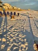 beach chairs on a sandy beach in a circle around a bonfire pit